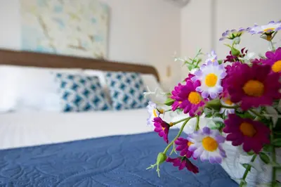 a bouquet of purple and white flowers sitting on a bed at Seascape Village - Spacious 3-Bed Apartment with Private Garden and Parking in Kalithies