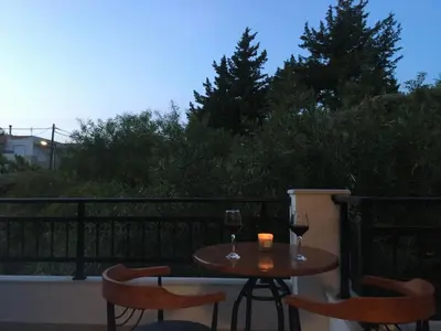 a table with two glasses of wine on a balcony at Seascape Village - Spacious 3-Bed Apartment with Private Garden and Parking in Kalithies