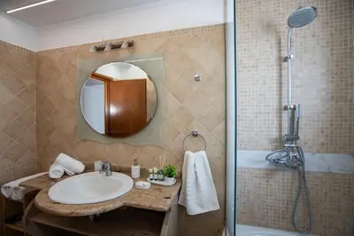 a bathroom with a sink and a shower at Seascape Village - Spacious 3-Bed Apartment with Private Garden and Parking in Kalithies