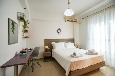 a bedroom with a bed and a desk and a window at Seascape Village - Spacious 3-Bed Apartment with Private Garden and Parking in Kalithies