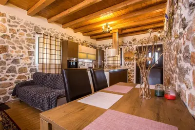 a kitchen and dining room with a wooden table at Villa in the Woods in Kolimbia