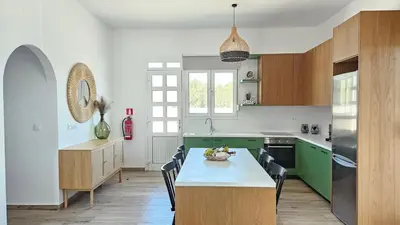 a kitchen with green cabinets and a table with a bowl of fruit at Villa Stamos with Seaview and Private Pool - Partner of Prasonisi Villas in Plimmiri