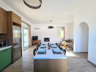 a large kitchen and living room with a long table at Villa Stamos with Seaview and Private Pool - Partner of Prasonisi Villas in Plimmiri