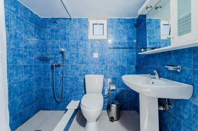 a blue tiled bathroom with a toilet and a sink at Villa Stamos with Seaview and Private Pool - Partner of Prasonisi Villas in Plimmiri