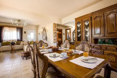 a dining room with a table and a living room at Laylande House in Theologos