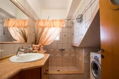 a bathroom with a sink and a washing machine at Laylande House in Theologos