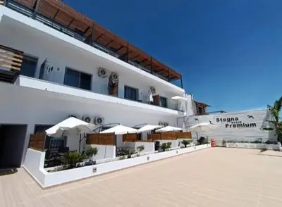 a large white building with umbrellas in a courtyard at Stegna Premium in Archangelos