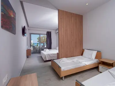 a hotel room with two beds and a balcony at Stegna Premium in Archangelos