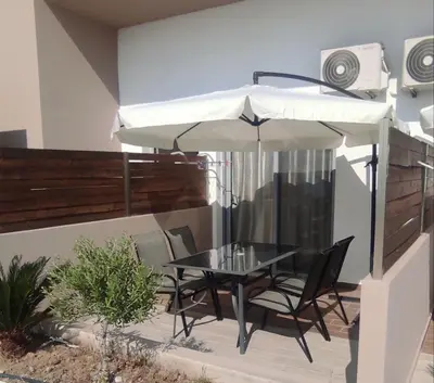 a table and chairs under an umbrella on a patio at Stegna Premium in Archangelos