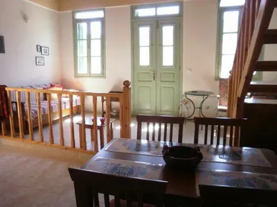 a living room with a table and chairs and a door at Andreas Apartments in Symi