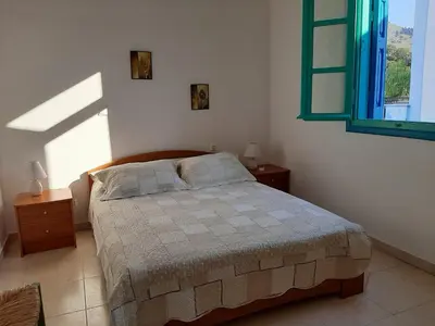 a bedroom with a bed and a window in it at Andreas Apartments in Symi