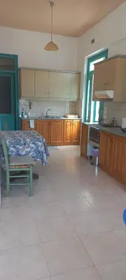 a large kitchen with wooden cabinets and a table at Andreas Apartments in Symi