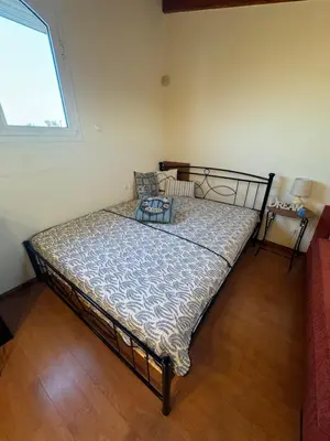 a bedroom with a bed in a room with a window at Kiotari Stone House in Gennadi