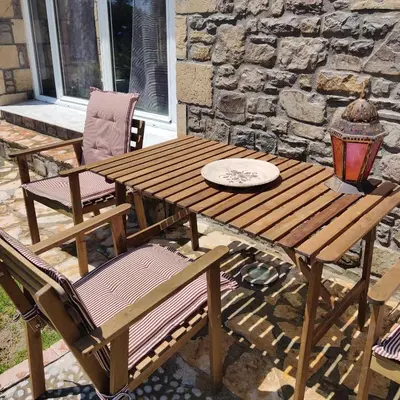 a wooden picnic table and chairs on a patio at Kiotari Stone House in Gennadi