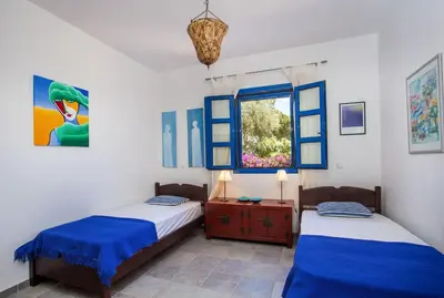 two beds in a room with a window at Villa Blue Sapphire in Pefki Rhodes