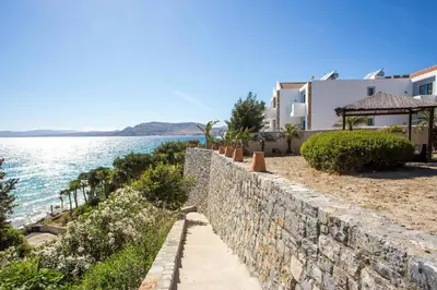 a stone retaining wall next to the water at Villa Blue Sapphire in Pefki Rhodes