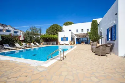a swimming pool with chairs and a building at Villa Blue Sapphire in Pefki Rhodes