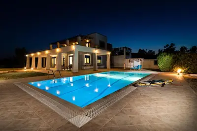 a swimming pool in front of a house at night at The 