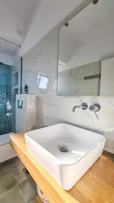 a bathroom with a white sink and a mirror at The 