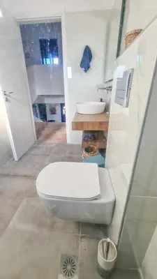 a bathroom with a white toilet and a sink at The 