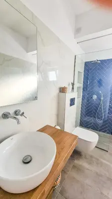 a white bathroom with a sink and a toilet at The 