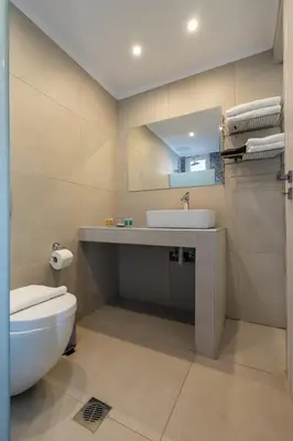 a bathroom with a white toilet and a sink at Bivalvia Studios in Faliraki