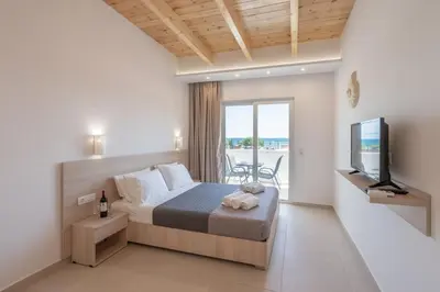 a bedroom with a bed and a tv and a balcony at Bivalvia Studios in Faliraki