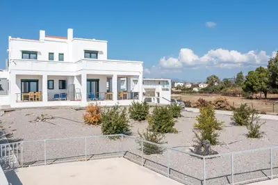 a white house with a fence in front of it at Kelly's Beach House 2 in Gennadi