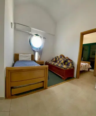 a bedroom with two beds and a mirror in it at Kelly's Beach House 2 in Gennadi