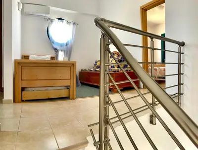a stair railing in a hallway with a room at Kelly's Beach House 2 in Gennadi
