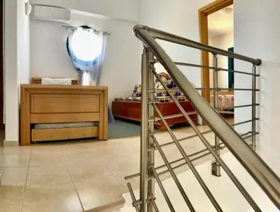 a room with a staircase and a bedroom with a bed at Kelly's Beach House 2 in Gennadi