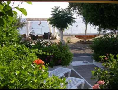 a hammock and chairs in a yard with the beach at Villa Tsampika in Pefki Rhodes