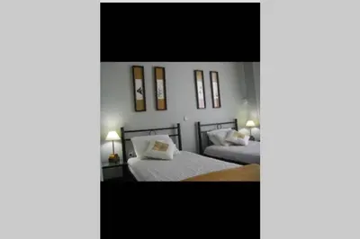 two beds in a room with white walls at Villa Tsampika in Pefki Rhodes