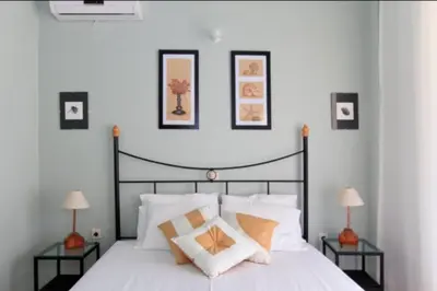 a bedroom with a large white bed with two tables at Villa Tsampika in Pefki Rhodes
