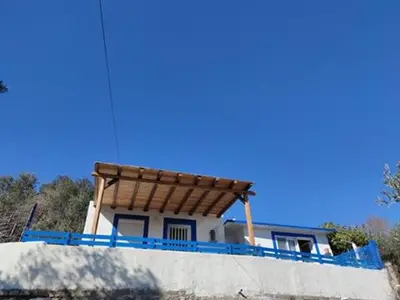 a house with a wooden roof on top of a wall at Ioli's Apartments in Archangelos