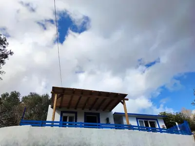 a house with a wooden roof on top of a wall at Ioli's Apartments in Archangelos