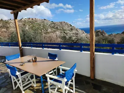 a table and chairs on a balcony with a view of the ocean at Ioli's Apartments in Archangelos