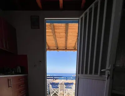 a door to a kitchen with a view of the ocean at Ioli's Apartments in Archangelos