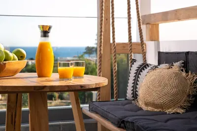 a table with two glasses of orange juice and a bowl of fruit at Pefkos Allure Luxury Suites with Jacuzzi in the heart of Pefkos!!! in Pefki Rhodes