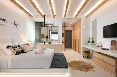 a bedroom with a white bed and a bathroom at Pefkos Allure Luxury Suites with Jacuzzi in the heart of Pefkos!!! in Pefki Rhodes