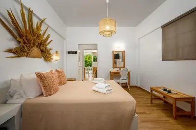 a bedroom with a large bed and a table at Afroditi Superior Apartments in Archangelos