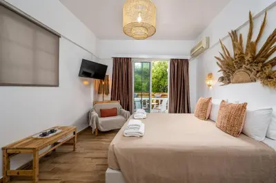 a hotel room with a large bed and a table at Afroditi Superior Apartments in Archangelos
