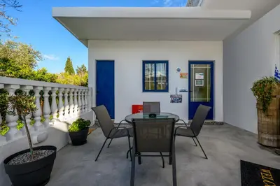 an outdoor patio with a table and chairs at Afroditi Superior Apartments in Archangelos