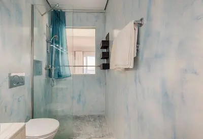 a bathroom with a toilet and a glass shower at Mike's Studios in Haraki