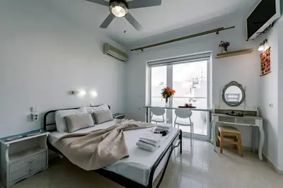 a bedroom with a bed and a desk and a window at Mike's Studios in Haraki