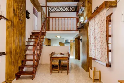 a dining room with a table and a wooden staircase at Hara's Traditional Detached House in Malona in Malona Village