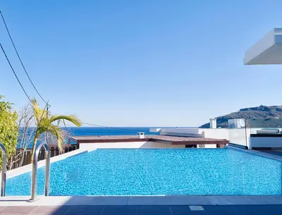 a swimming pool on top of a building with the ocean in the background at Villa Tamara in vlicha