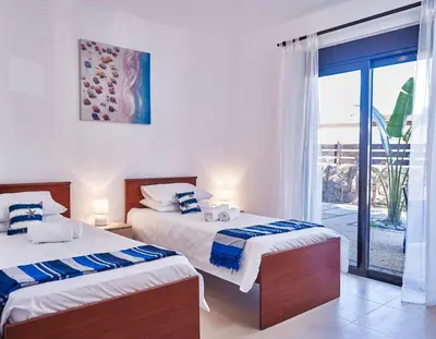 a bedroom with two beds and a balcony at Villa Tamara in vlicha