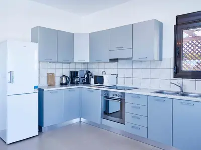 a kitchen with white cabinets and a white refrigerator at Villa Tamara in vlicha