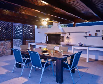 a kitchen with a wooden table and blue chairs at Villa Tamara in vlicha
